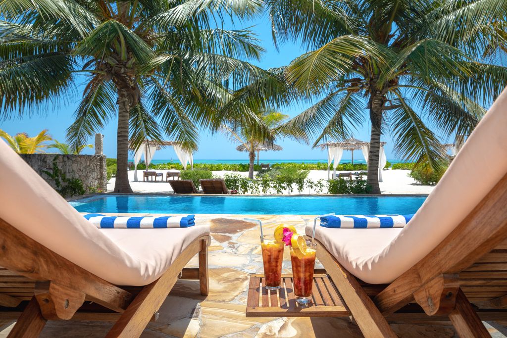 Enjoying holidays at private swimming pool in luxury resort near Indian ocean (Zanzibar island, Tanzania)