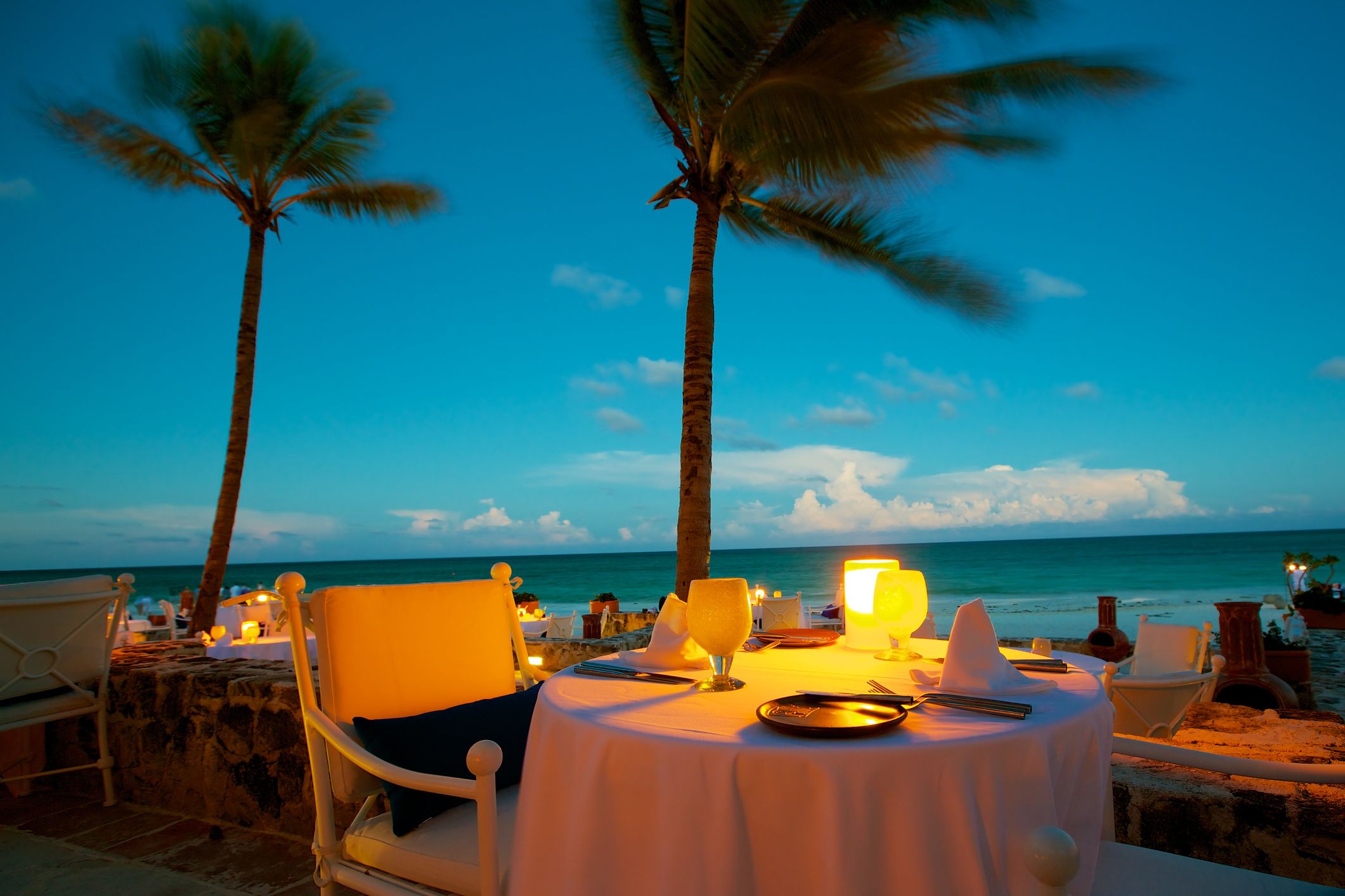 Romantic dining setting on a Caribbean beach at sunset