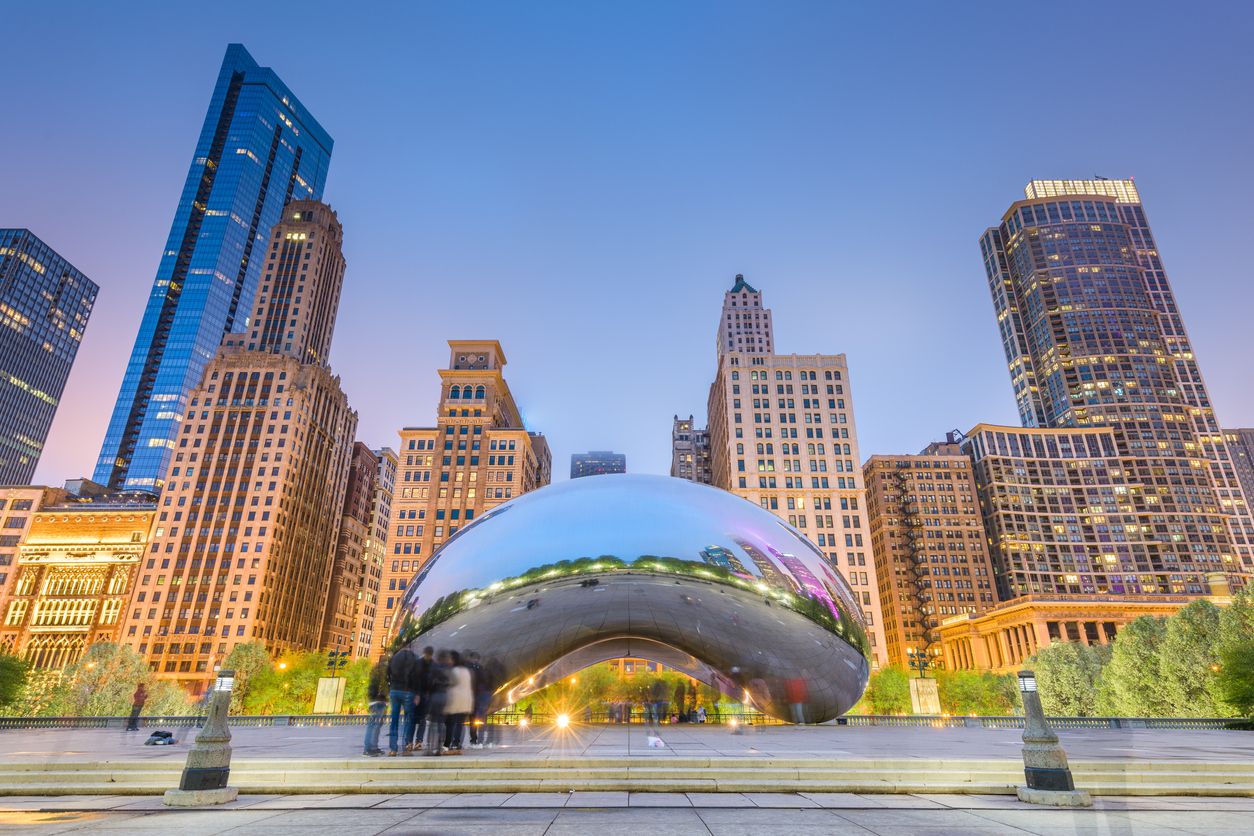 Tourists visit Cloud Gate in Millennium Park in the evening with "The Bean" in focus