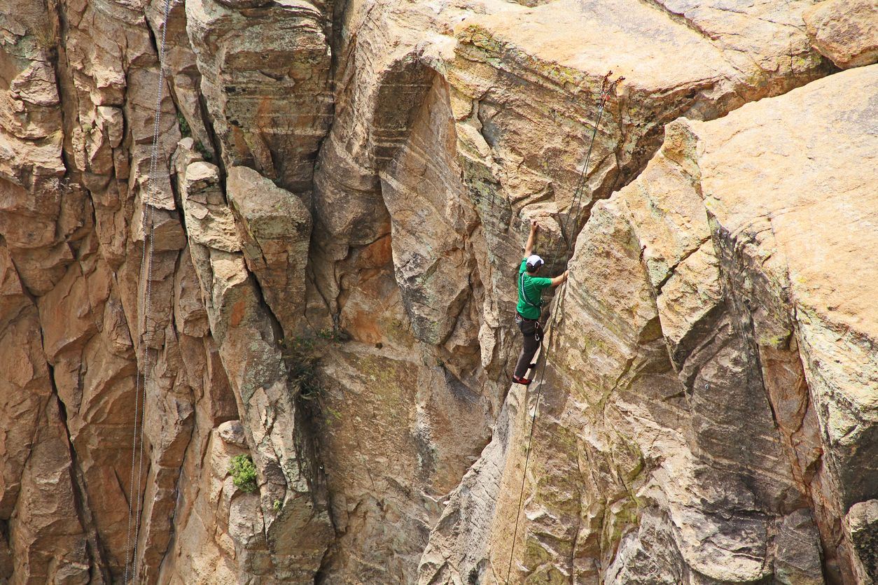 Man top rope climbing a hoodoo near Windy Point on Mount Lemmon in Tucson, Arizona, USA