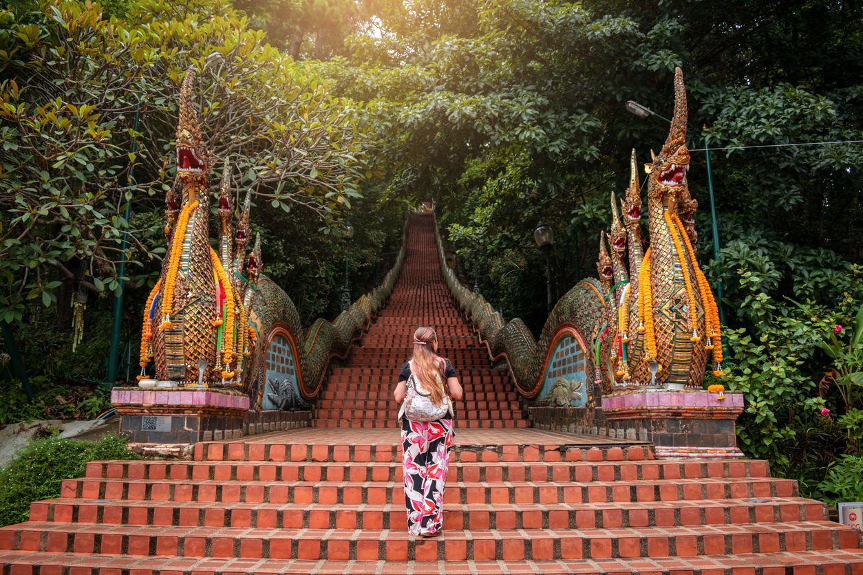 Young woman walking up the stairs of the temple, Doi Suthep in Chiang Mai, Thailand