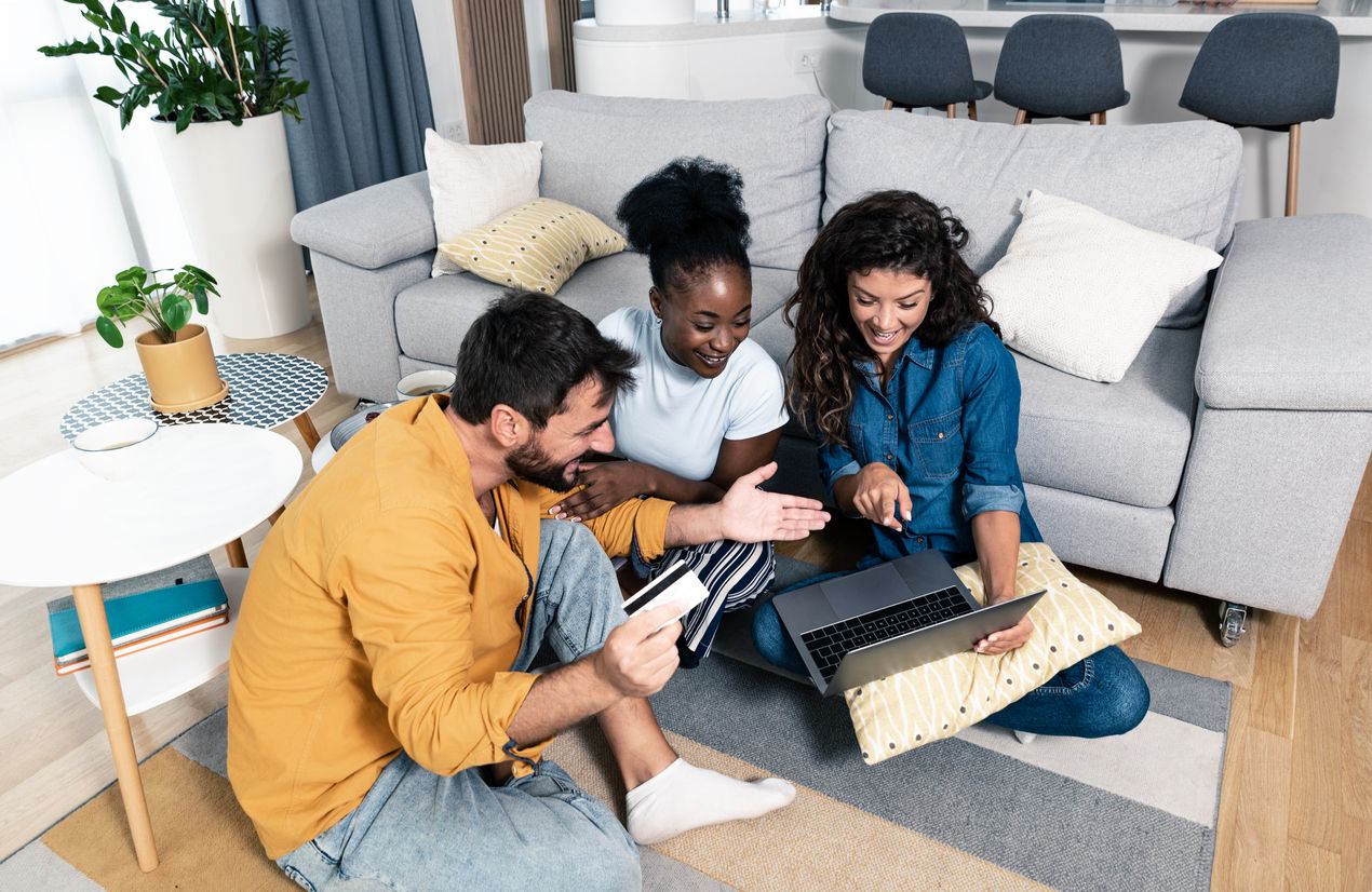Three excited friends buying a vacation tickets trip online.