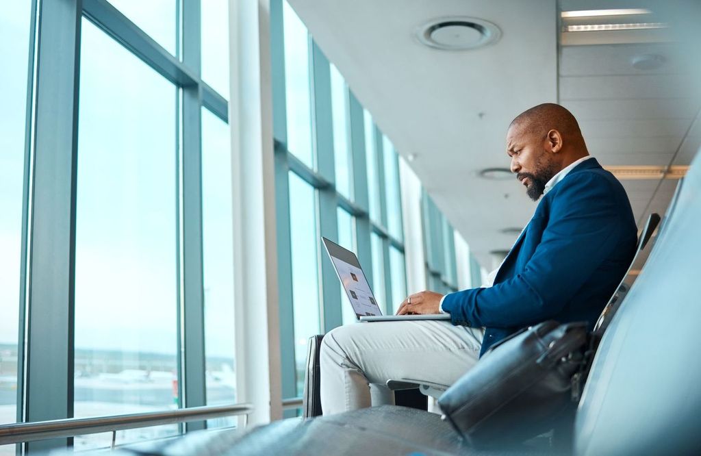 Man in airport online booking trip