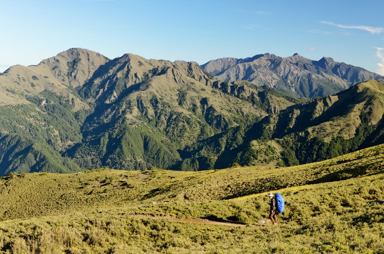 Single mountaineer man walking on grassland in Yushan national park, Taiwan, Asia