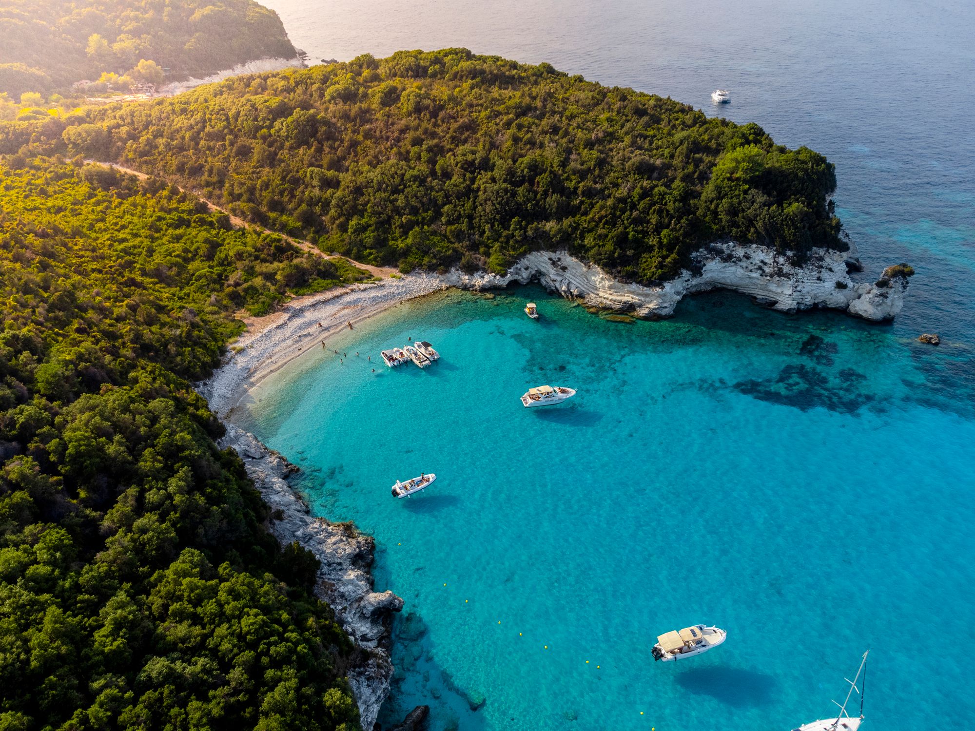 Aerial view of Antipaxos island near Corfu, Greece with boats lined around the coastline.