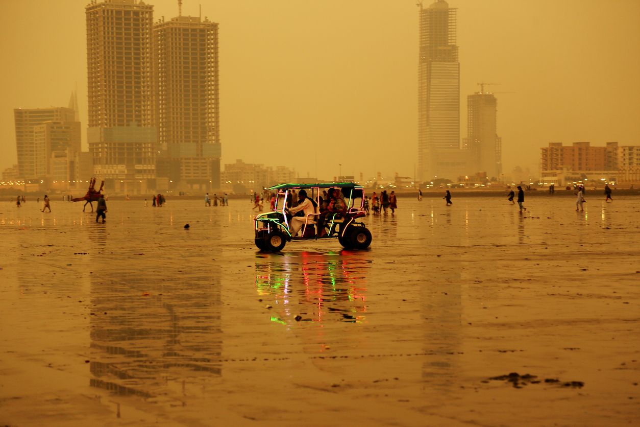Locals riding beach buggy illuminated with LED lights at Clifton Beach, Karachi