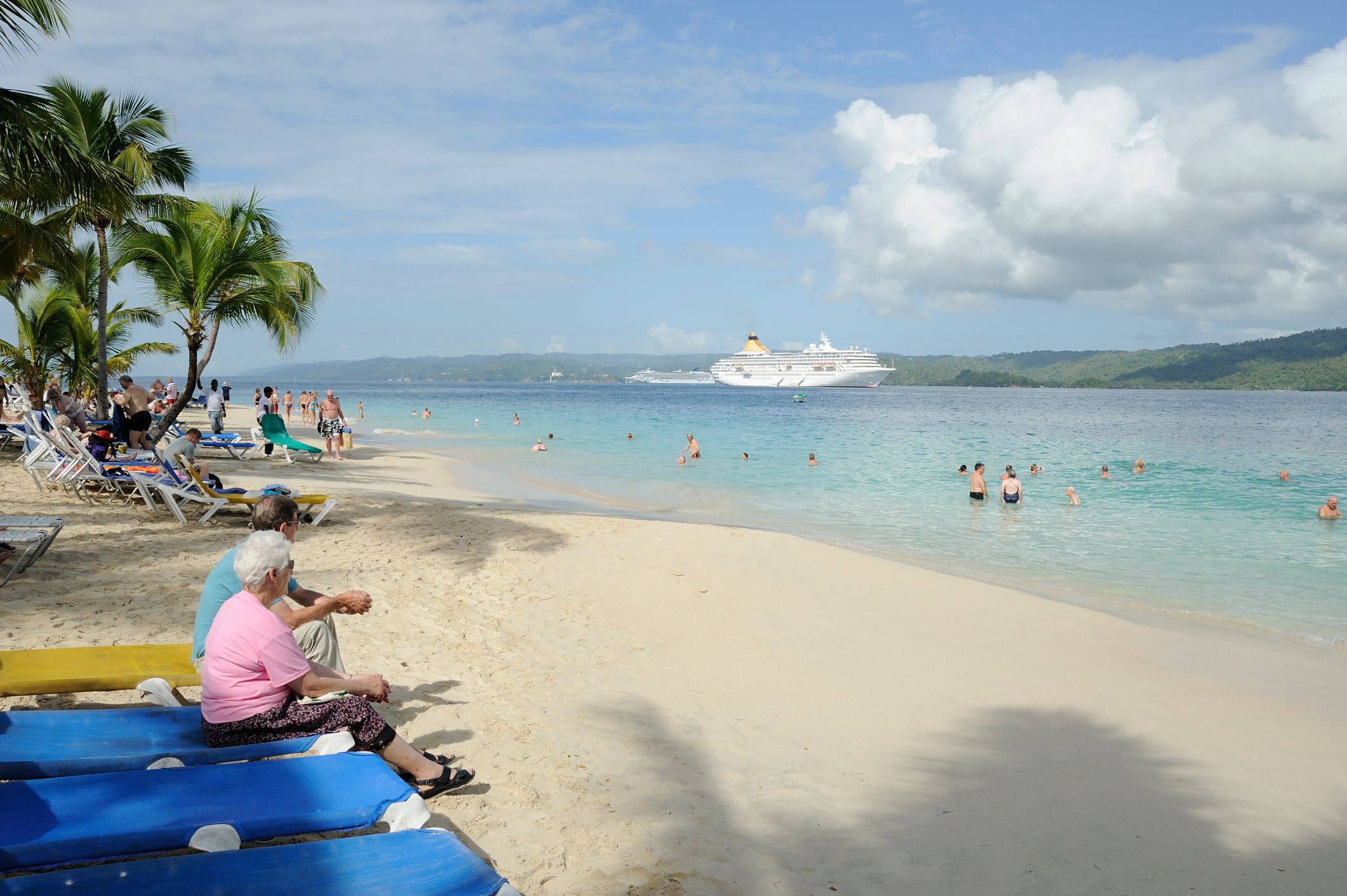 People on the beach with a cruise liner in the background at Cayo Levantado, Dominican Republic