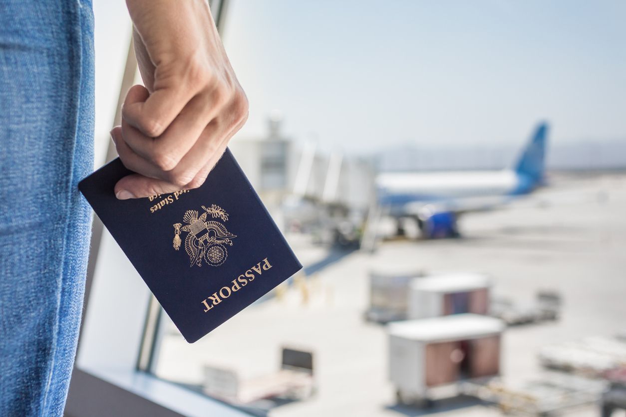 Woman at the airport with an American passport in hand