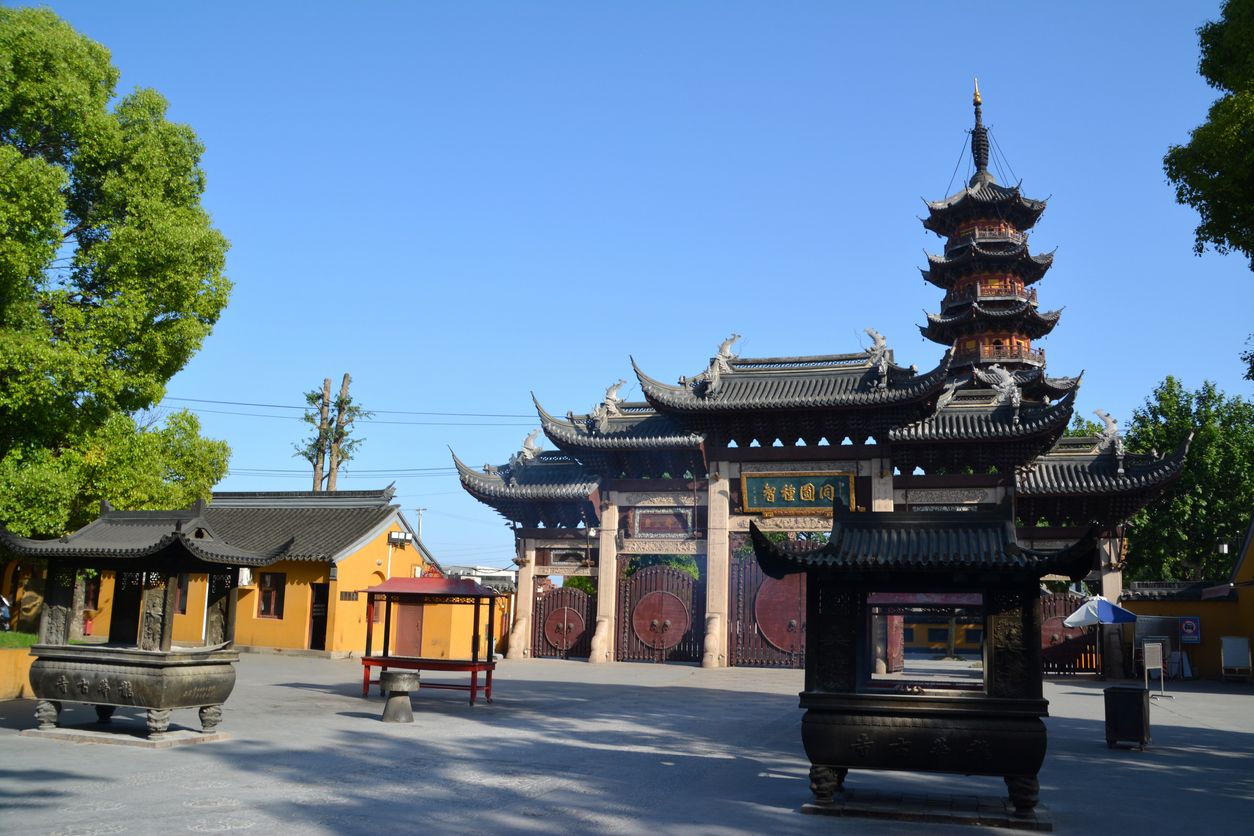 The old Longhua Temple, a Buddhist Temple dedicated to the Maitreya Buddha. In the background the Longhua Pagoda, on a clear sunny day. Shanghai, China
