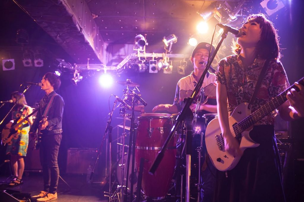 A rock music band is having a live concert in a bar in Tokyo