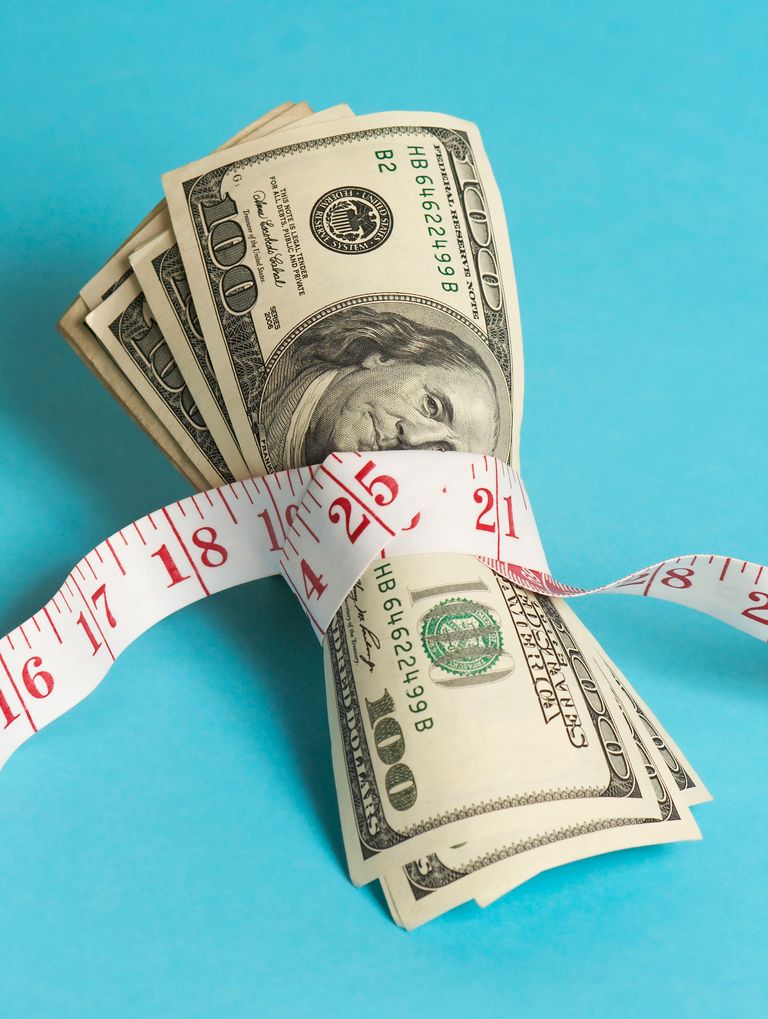  bunch of hundred dollar bills tightly tied with a tape measure