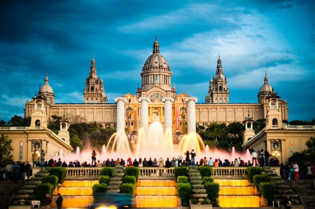 Tourists watching colorful fountain Font MA gica show at Montjuic MNAC. Barcelona, Catalonia, Spain