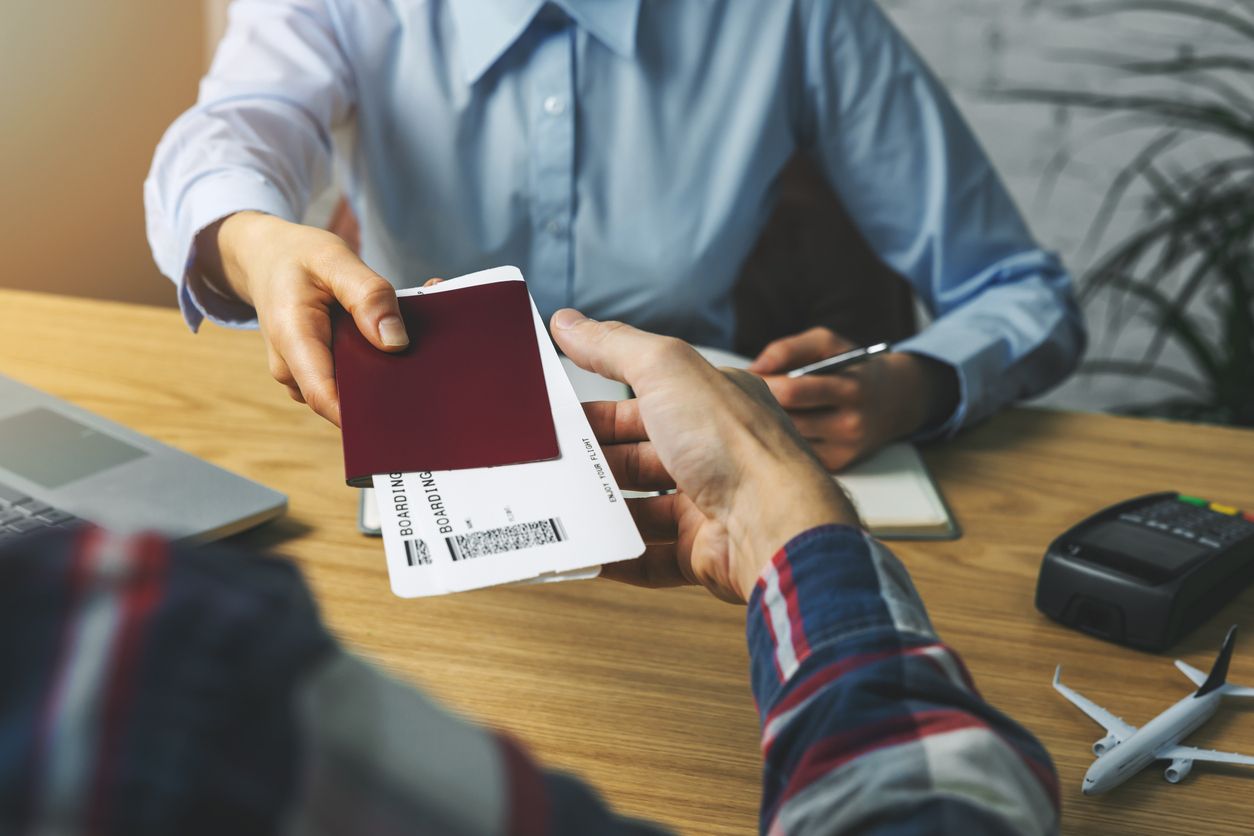 Travel agent giving flight tickets and documents to customer