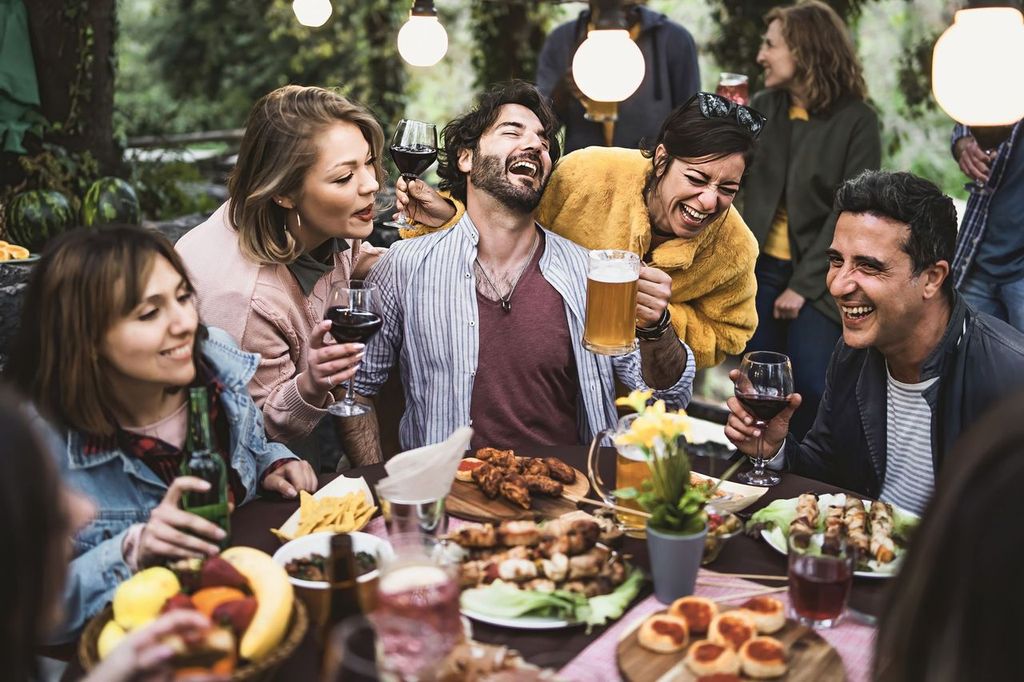 People having fun drinking beer, wine, and eating together