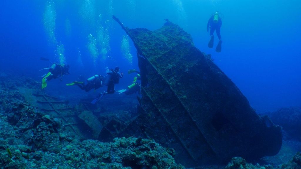 Recreational scuba divers in underwater wreck near Liuqiu Island, Pingtung, Taiwan