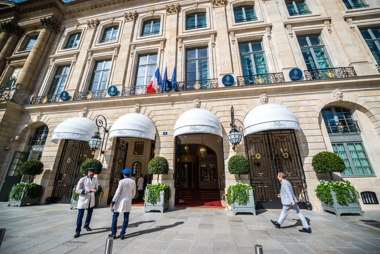 Famous Hotel Ritz on Place Vendome, Paris. Man walking to the hotel. Concierges at the entrance.