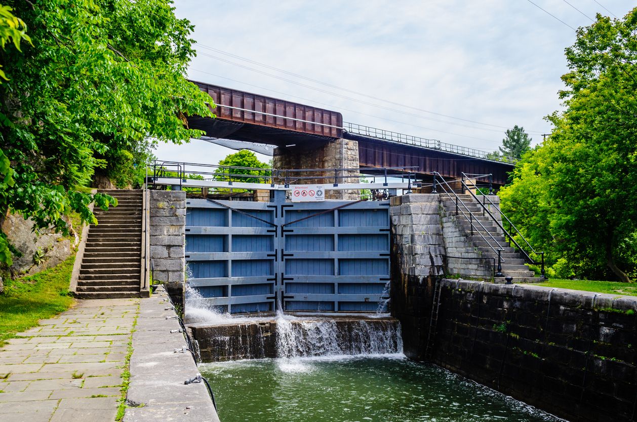 Lock in canal with railway bridge passing above, near Kingston, Ontario, Canada