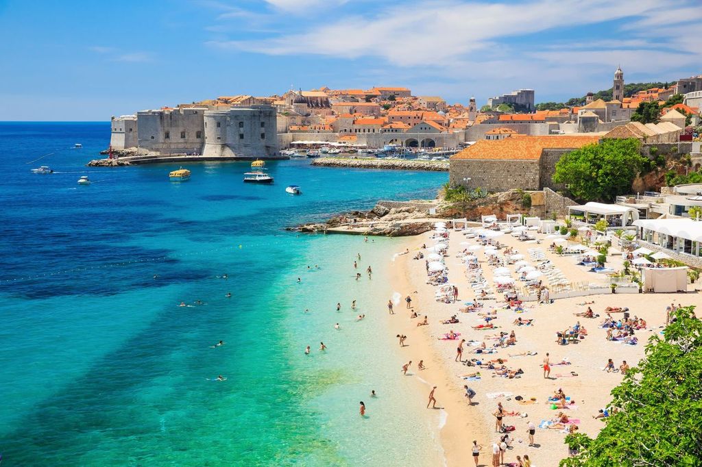 people sunbathing on the shores of the walled city, Dubrovnik Croatia