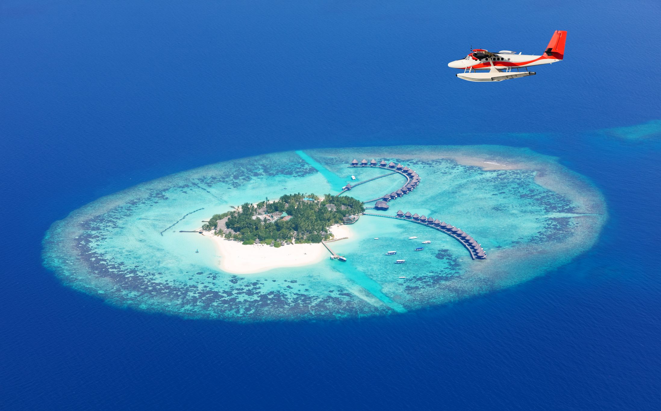 Sea plane tour flying above Maldives islands, affordable for travelers staying in the Maldives on a $15,000 vacation.