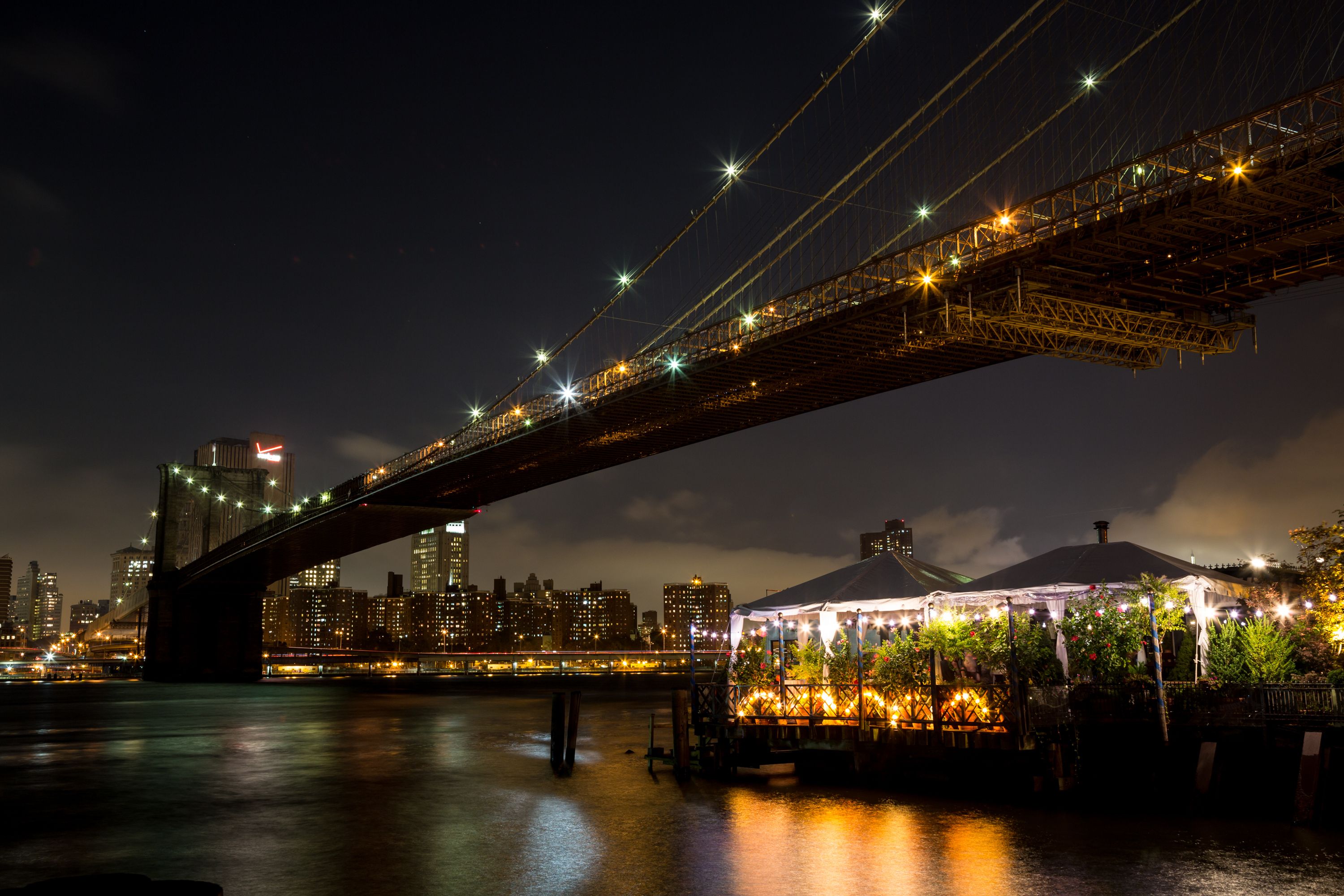 Brooklyn Bridge at night New York City and the famous Michellin-Starred restaurant, The River Cafẻ.