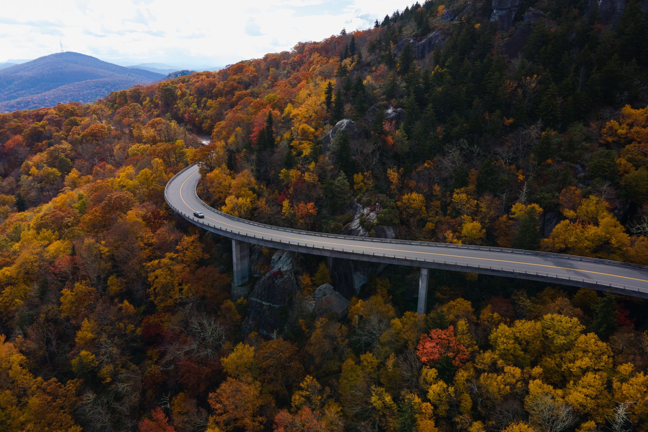 Aerial of a Blue Ridge Parkway through a forest in autumn